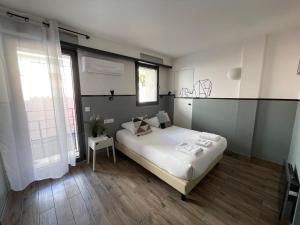 a bedroom with a white bed and a large window at Casa Hotel in Aix-en-Provence