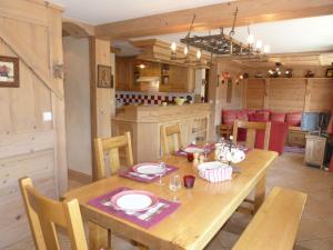 a dining room with a wooden table and a kitchen at Appartement La Clusaz, 5 pièces, 8 personnes - FR-1-304-40 in La Clusaz