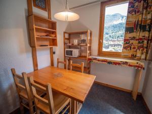 a dining room with a wooden table and a window at Appartement Valmorel, 1 pièce, 4 personnes - FR-1-356-254 in Valmorel