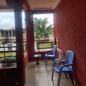 a room with two blue chairs and a window at RÉSIDENCE VICTORIA in Lomé