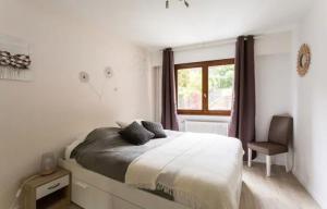 Schlafzimmer mit einem Bett, einem Fenster und einem Stuhl in der Unterkunft DRYADES SAINT GERVAIS in Saint-Gervais-les-Bains