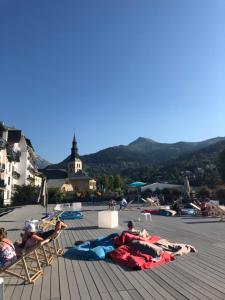 eine Gruppe von Menschen, die auf einer Terrasse auf Gartenstühlen liegen in der Unterkunft DRYADES SAINT GERVAIS in Saint-Gervais-les-Bains