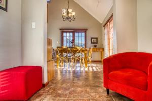 a dining room with red chairs and a table at Lady Grey Walk Mcgregor Cottage in McGregor