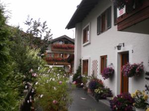 a white building with flowers in a courtyard at Ferienhaus Beim Veitele in Mittenwald