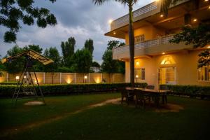 a house with a table and chairs in the yard at The Q Villa, Udaipur in Udaipur