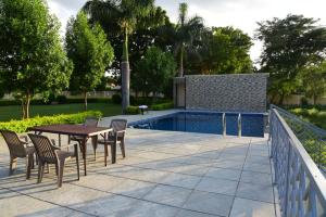 a patio with a table and chairs next to a pool at The Q Villa, Udaipur in Udaipur