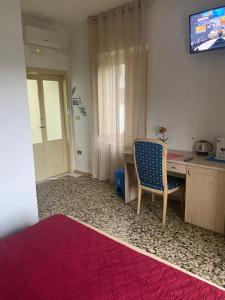 Zimmer mit einem Schreibtisch, einem Stuhl und einem TV in der Unterkunft B&b il Vico in Tarsia