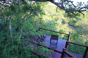 a wooden deck with a chair sitting on it at Parsons Hilltop Safari Camp in Balule Game Reserve