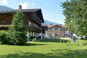 une grande maison avec une aire de jeux dans la cour dans l'établissement Landhaus Gredler, à Mayrhofen