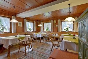 a dining room with tables and chairs and windows at Landhaus Gredler in Mayrhofen +29 photos