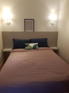 a bed with two pillows on it in a room at Maison de ville Forum Julii in Fréjus