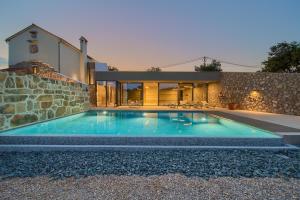 a swimming pool in front of a house at Luxury Jerini Estate in Krk