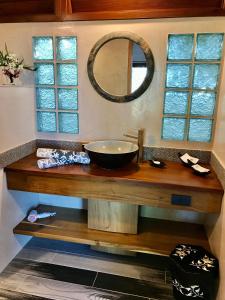 ein Waschbecken im Bad mit einer Schüssel auf einer Holztheke in der Unterkunft Jasmin Garden Koh Kood in Ko Kood