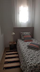 a bedroom with a bed with a window and a rug at Maison de ville Forum Julii in Fréjus