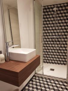 La salle de bains est pourvue d'un lavabo blanc et d'une douche. dans l'établissement Maison de ville Forum Julii, à Fréjus