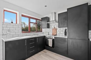 a kitchen with black and white appliances and windows at Entire beautiful home in the heart of Huntingdon, Bury in Bury