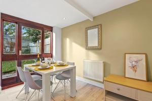 uma sala de jantar com uma mesa branca e cadeiras em Entire beautiful home in the heart of Huntingdon, Bury em Bury