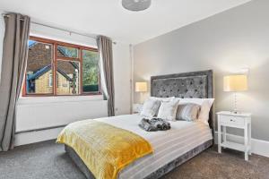 a bedroom with a bed with a large window at Entire beautiful home in the heart of Huntingdon, Bury in Bury