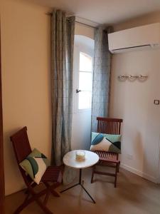 a room with two chairs and a table and a window at Maison de ville Forum Julii in Fréjus