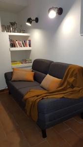 a blue couch with a blanket on it in a living room at Maison de ville Forum Julii in Fréjus