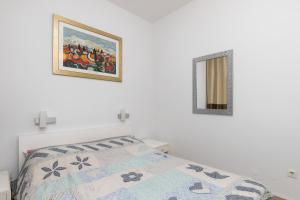 Apartment Van Gogh في دوبروفنيك: غرفة نوم بسرير ودهان على الحائط