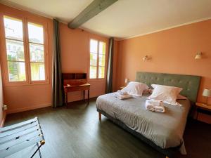 een slaapkamer met een bed met twee handdoeken erop bij La Petite Fontaine in Saint-Émilion