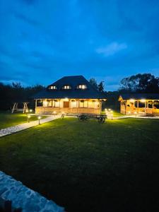 a large building with lights in a field at night at Casa Moroșanului Vișeu de Sus in Vişeu de Sus +72 photos