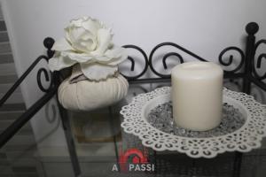 una vela en una mesa junto a un jarrón con una flor en A 2 Passi da Stesicoro Suite Catania, en Catania