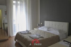 Un dormitorio con una cama grande con toallas. en A 2 Passi da Stesicoro Suite Catania, en Catania