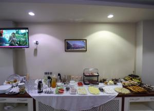 einen Tisch mit einem weißen Tischtuch und Essen drauf in der Unterkunft Christi's Hotel Borova in Korçë