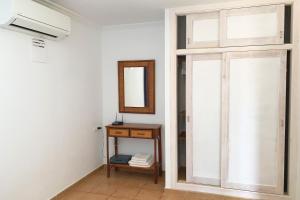 een kamer met een raam, een spiegel en een tafel bij La Casita Yolanda, ideal parejas - Formentera Natural in Sant Ferran de Ses Roques