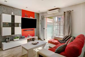 ein Wohnzimmer mit einem roten Sofa und einem TV in der Unterkunft Villa Hyc Playa de las burras in Maspalomas