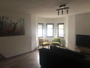 een woonkamer met een bank en een tv bij Aparthaus-Kiebitz in Rennweg