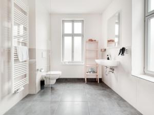 a white bathroom with a sink and a toilet at limehome Erfurt Bürgermeister-Wagner-Straße in Erfurt