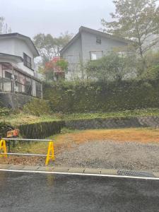 una casa al lado de una carretera con una valla en Oyado Zen, en Kusatsu