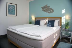 ein Schlafzimmer mit einem großen Bett mit weißer Bettwäsche in der Unterkunft strandnah, Wintergarten, gratis Nutzung vom AHOI Erlebnisbad und Sauna in Sellin - Strandhaus Mönchgut FeWo08 in Lobbe + 22 Fotos