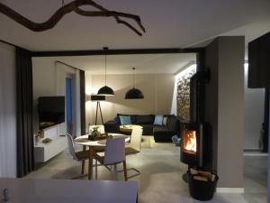 Una sala de estar con una mesa y una chimenea. en Apartamenty Moszna - blisko Zamku, Jacuzzi, widok na las, en Moszna