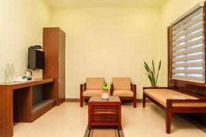 a waiting room with two chairs and a tv at Golden Fern Resort in Kanthalloor