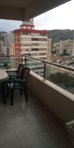 two chairs on a balcony with a view of a city at Apartamento Completo Torresol IV in Benidorm