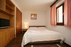 a bedroom with a bed and a flat screen tv at Apartments Neda - Poreč South in Poreč