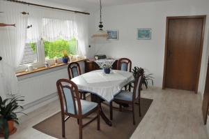 a dining room with a table and chairs and a window at Ferienwohnung Bruns 15028 in Leer
