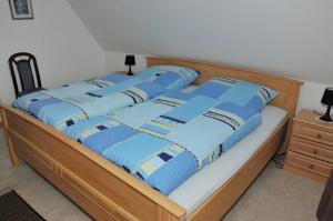 a bed with blue blankets and pillows on it at Ferienwohnung Bruns 15028 in Leer