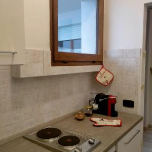 a kitchen counter with a stove and a window at La Casa al Mare di Giulia in Porto Potenza Picena