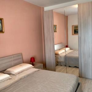 a bedroom with two beds and a mirror at La Casa al Mare di Giulia in Porto Potenza Picena