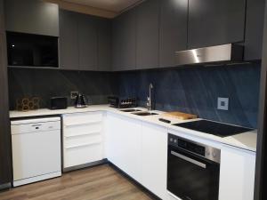 a kitchen with white cabinets and a stove top oven at Menlyn Residence - Luxury Business Apartment in Pretoria