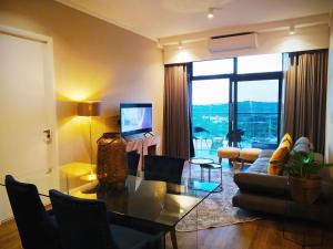 a living room with a glass table and a television at Menlyn Residence - Luxury Business Apartment in Pretoria