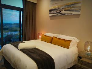 a bedroom with a large white bed with a window at Menlyn Residence - Luxury Business Apartment in Pretoria