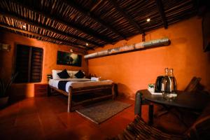 a bedroom with a bed and a table in a room at Golden Fern Resort in Kanthalloor