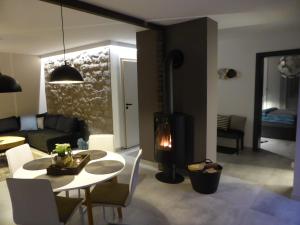Una sala de estar con una mesa y una chimenea. en Apartamenty Moszna - blisko Zamku, Jacuzzi, widok na las, en Moszna 53 fotos más