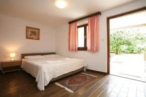 a bedroom with a bed and a large window at Apartments Neda - Poreč South in Poreč